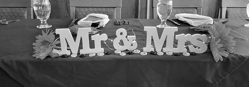 Image of a Mr and Mrs sign set up on the head wedding table in the Waterton Lakes Lodge event room.